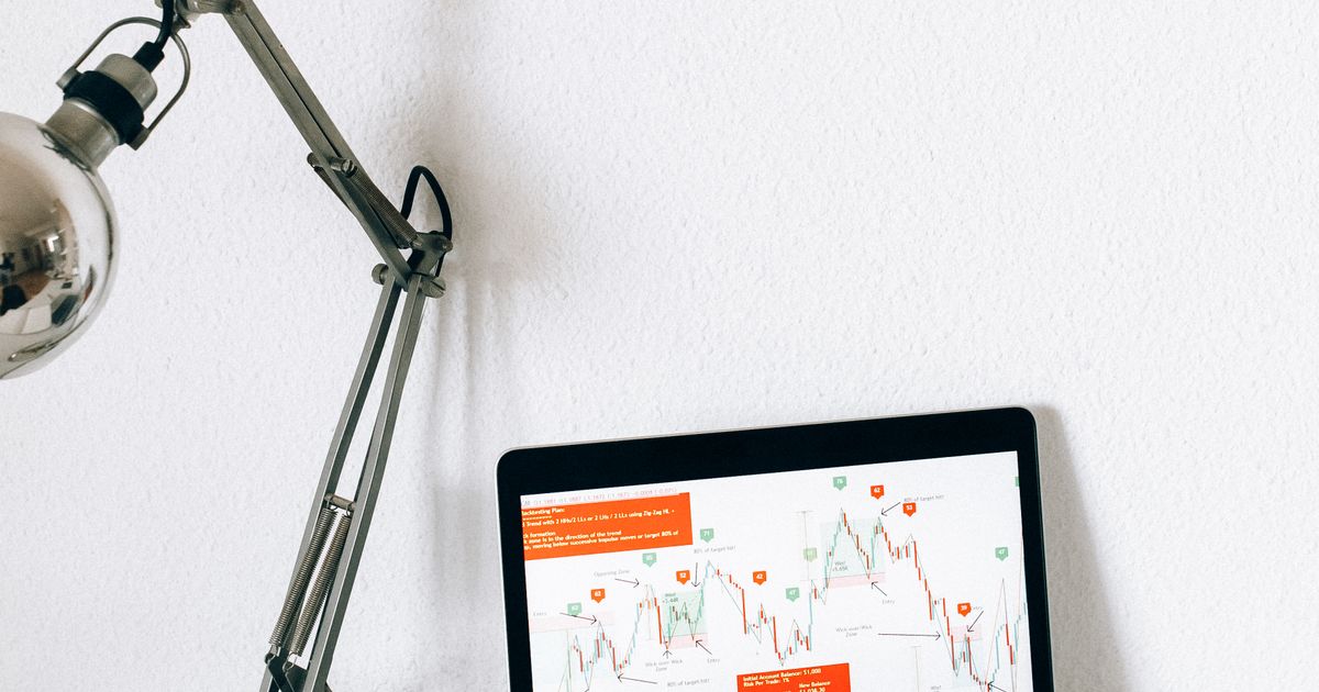 An analytical workspace with a notebook and charts on a laptop