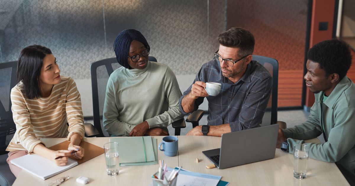 Colleagues discussing a project around a meeting table