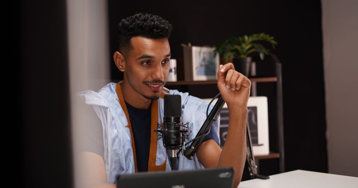 A speaker recording a conversation into a studio microphone
